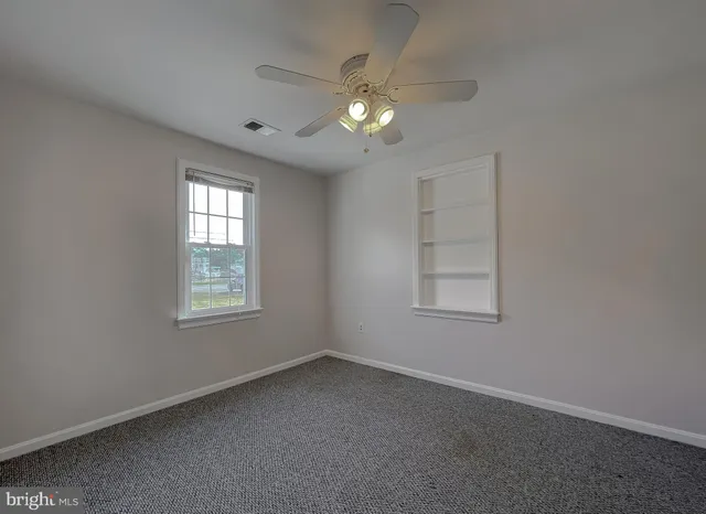 a view of a white house with a yard and sitting area