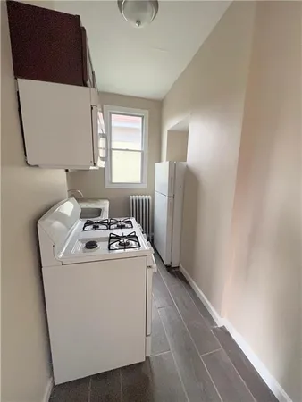 a kitchen with a stove a refrigerator and a window