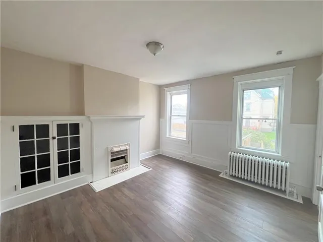 an empty room with windows and a fireplace