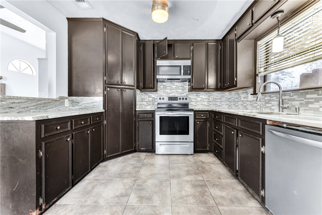 1220 Haley Place College Station, TX 77845 - Photo 5 of 20 a kitchen with stainless steel appliances granite countertop a stove a refrigerator and a sink