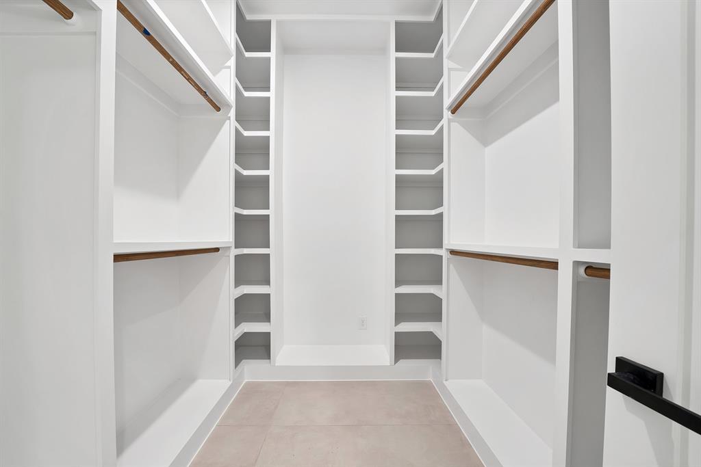 1415 Fayette Street Dallas, TX 75203 - Photo 28 of 40 Built-in custom closet system with white shelving and wood-finish hanging rods