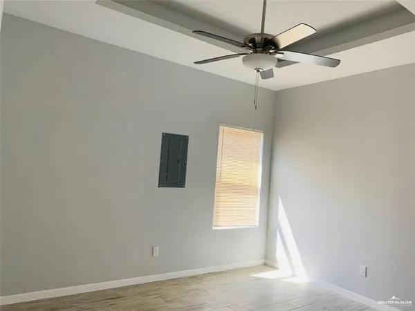 an empty room with a window and a ceiling fan
