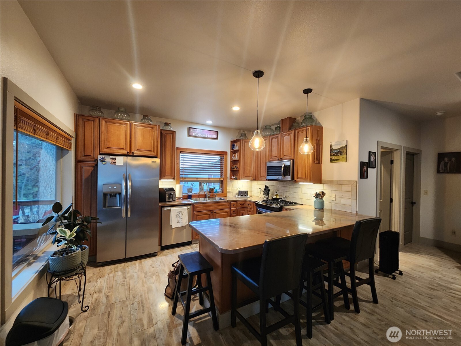 1054 Lower Madison Street Republic, WA 99166 - Photo 2 of 19 a kitchen with stainless steel appliances kitchen island granite countertop a refrigerator a stove a sink a dining table and chairs with wooden floor