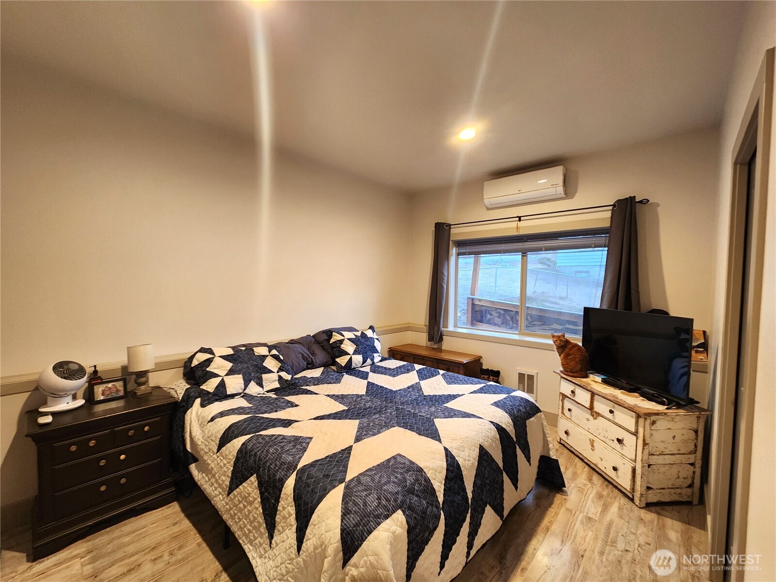 1054 Lower Madison Street Republic, WA 99166 - Photo 7 of 19 a bed sitting in a bedroom next to a flat screen tv with kitchen view