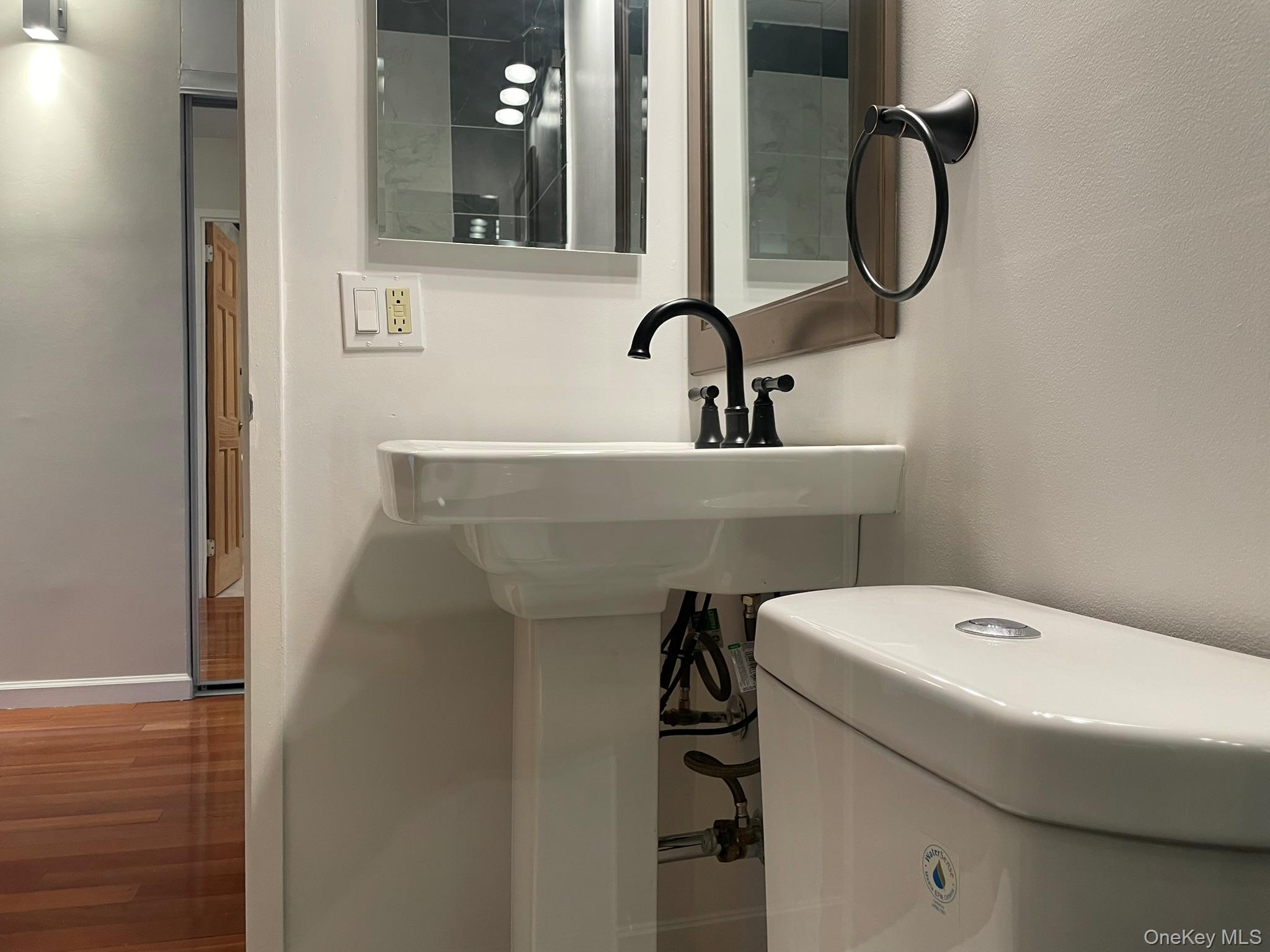 301 West 110th Street, Unit 14F Manhattan, NY 10026 - Photo 15 of 18 Half bath featuring baseboards and wood finished floors