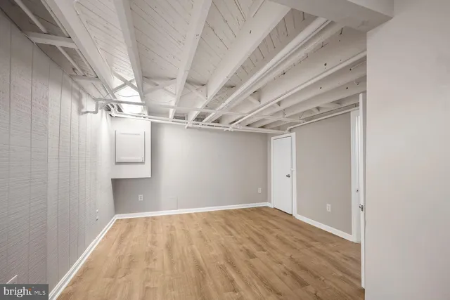 a view of empty room with wooden floor
