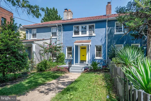 a front view of a house with yard and green space