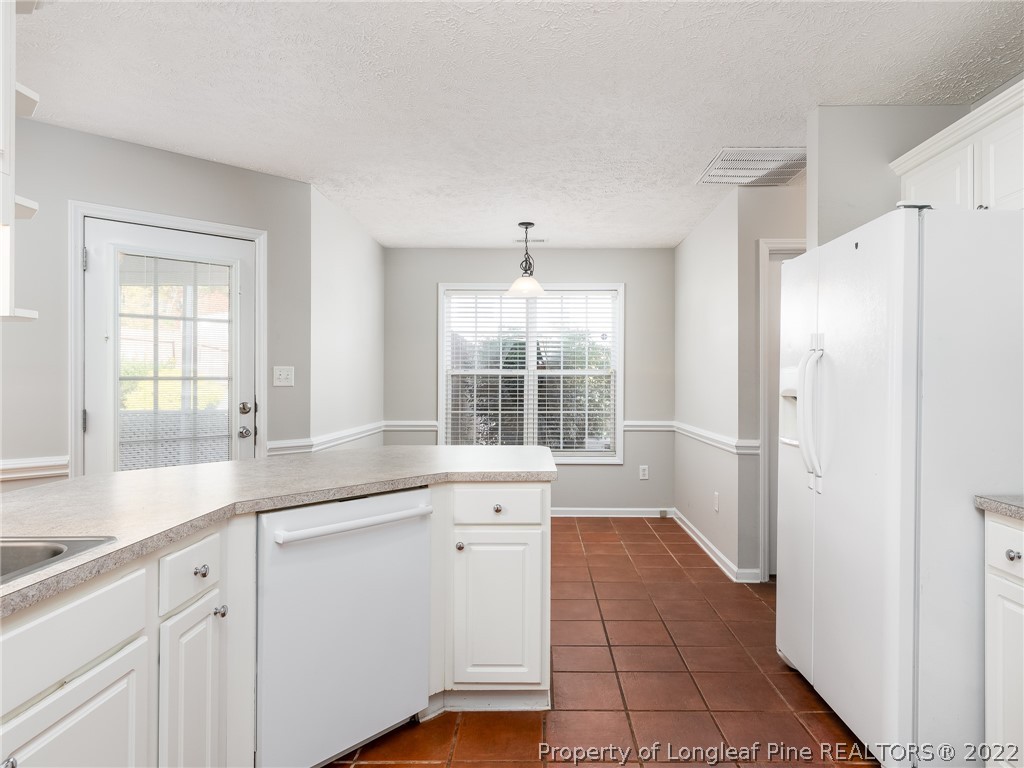 5716 Spreading Branch Road Hope Mills, NC 28348 - Photo 17 of 37 a kitchen with granite countertop white cabinets and white appliances