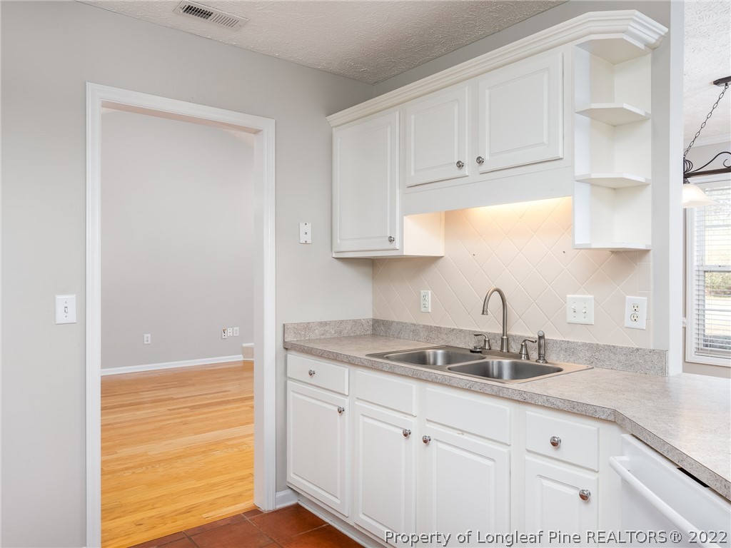 5716 Spreading Branch Road Hope Mills, NC 28348 - Photo 20 of 37 a kitchen with granite countertop white cabinets and white appliances