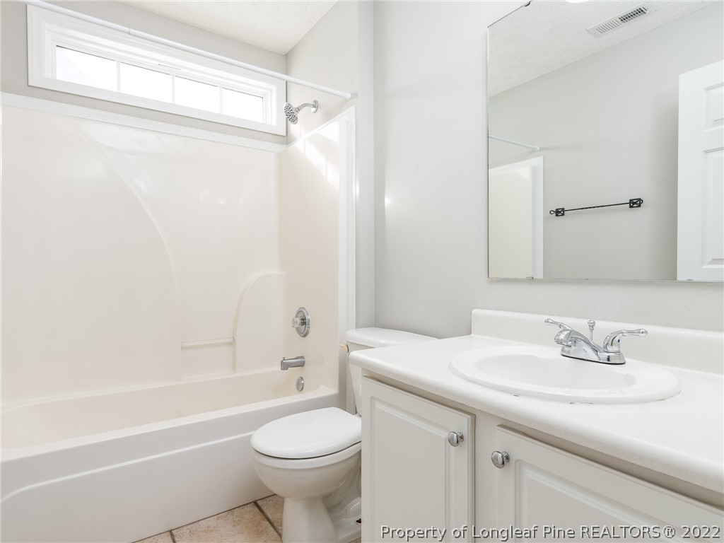 5716 Spreading Branch Road Hope Mills, NC 28348 - Photo 27 of 37 a bathroom with a sink a toilet and a bathtub