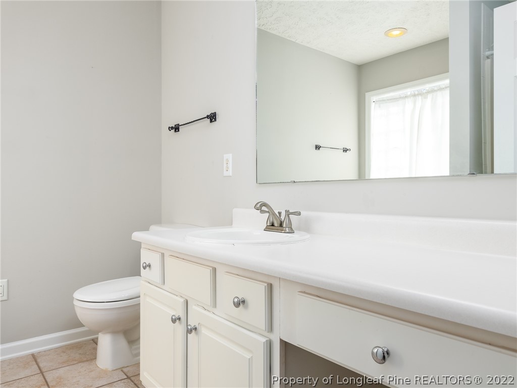 5716 Spreading Branch Road Hope Mills, NC 28348 - Photo 34 of 37 a bathroom with a sink a toilet and a window