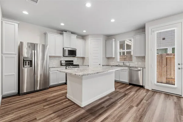 a kitchen with stainless steel appliances granite countertop a stove microwave and sink