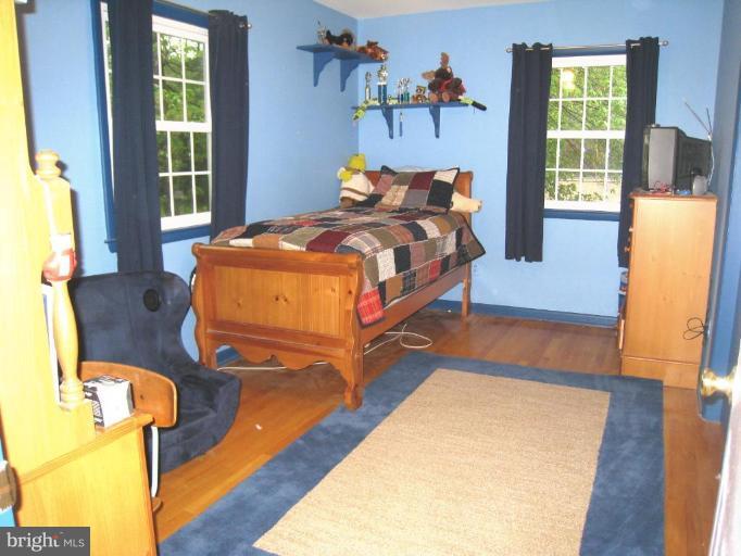 757 Hawthorne Road Linthicum Heights, MD 21090 - Photo 12 of 23 a bedroom with a bed and wooden floor