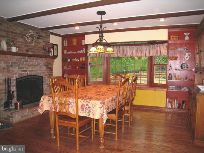 757 Hawthorne Road Linthicum Heights, MD 21090 - Photo 4 of 23 a dining room with furniture a fireplace and wooden floor