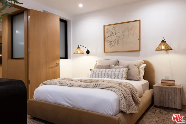 a bedroom with bed and wall painting