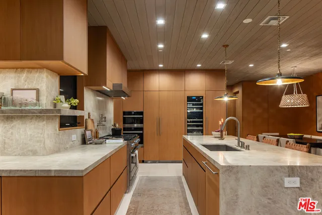 a kitchen with stainless steel appliances kitchen island granite countertop a sink and a stove
