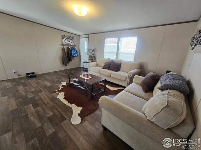 a large kitchen with stainless steel appliances granite countertop a refrigerator a sink dishwasher a dining table and chairs with wooden floor