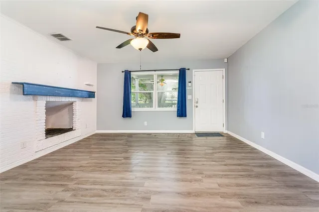 a view of an empty room with a fireplace and a window