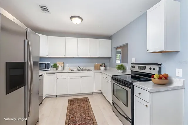 a kitchen with stainless steel appliances granite countertop a refrigerator sink and stove