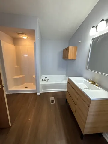 a bathroom with a tub sink and mirror