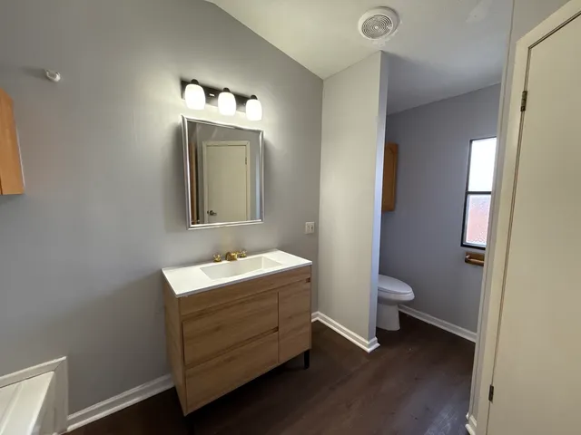 a bathroom with a toilet sink and mirror