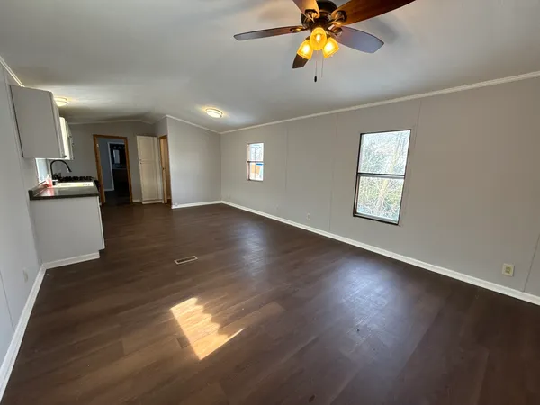 a view of an empty room with window and wooden floor