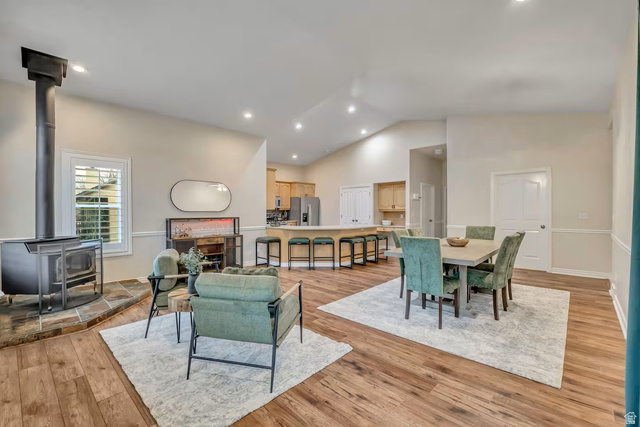 11789 Nicklaus Road Sandy, UT 84092 - Photo 15 of 58 Dining room featuring a wood stove, light wood finished floors, vaulted ceiling, and recessed lighting