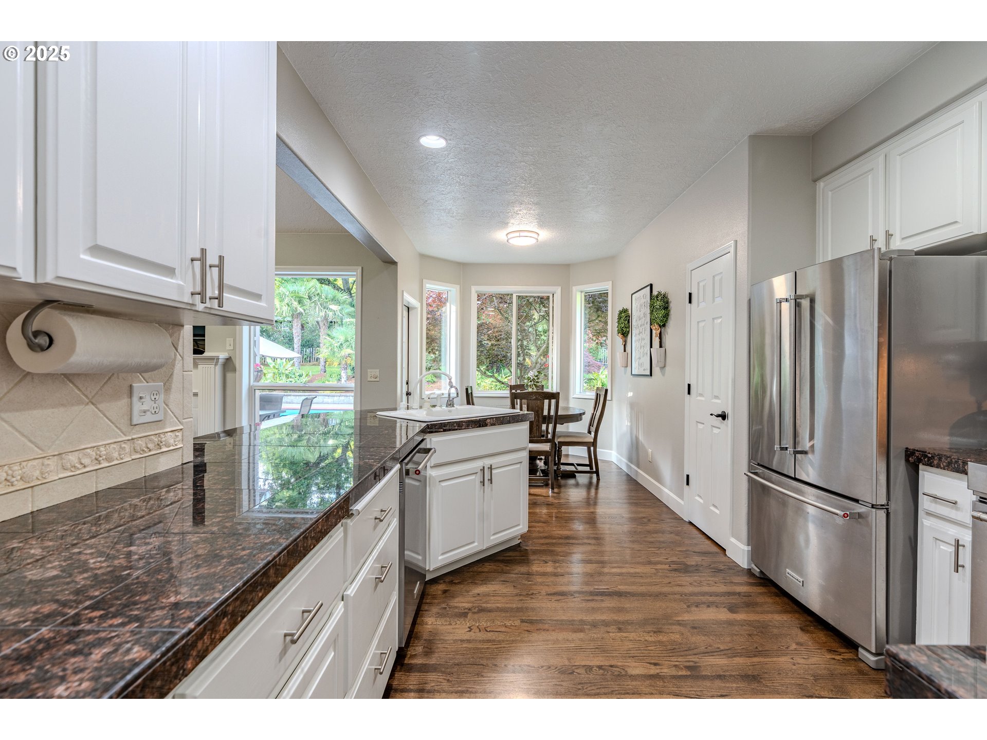 32153 Southeast Bluff Road Gresham, OR 97080 - Photo 13 of 48 a kitchen with stainless steel appliances granite countertop a refrigerator a sink dishwasher a stove and white countertops with wooden floor