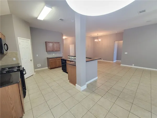 a view of a kitchen with furniture and a refrigerator