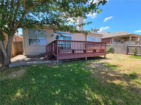 a view of a deck with a big yard potted plants and large tree