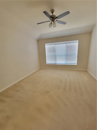 an empty room with a ceiling fan and a window