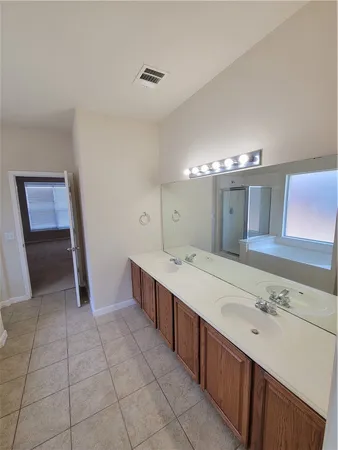 a large bathroom with a double vanity sink and a mirror