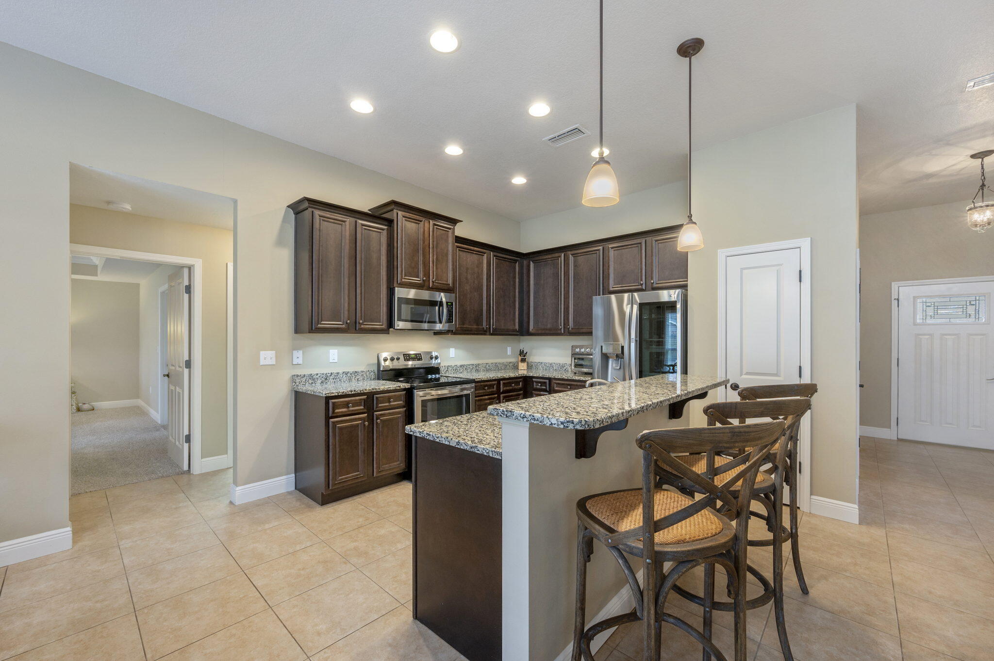 5811 Roberts Road Crestview, FL 32536 - Photo 12 of 35 a kitchen with stainless steel appliances granite countertop a stove top oven a sink island and a refrigerator
