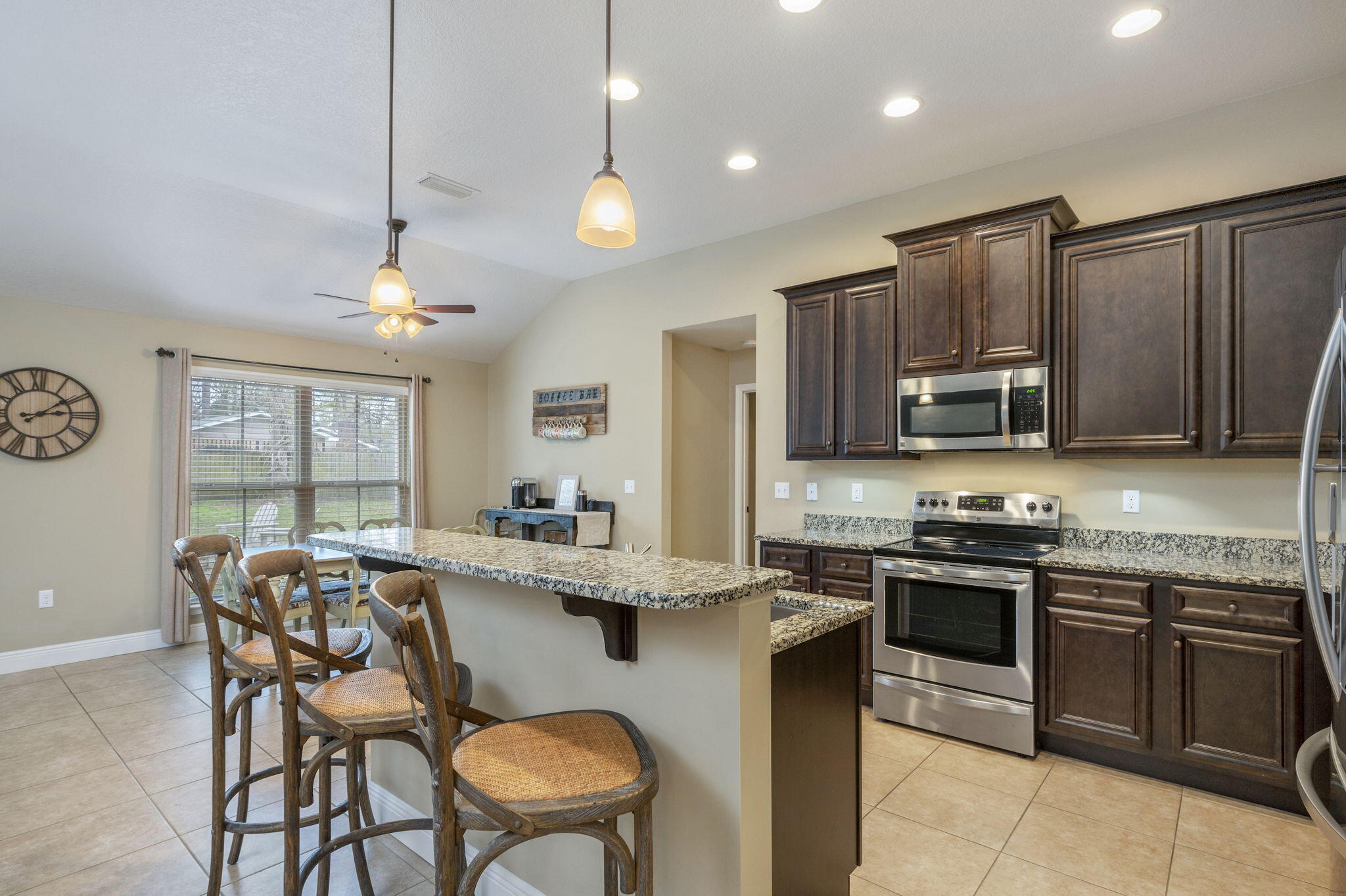 5811 Roberts Road Crestview, FL 32536 - Photo 14 of 35 a kitchen with stainless steel appliances granite countertop a stove top oven a sink a stove a dining table and chairs