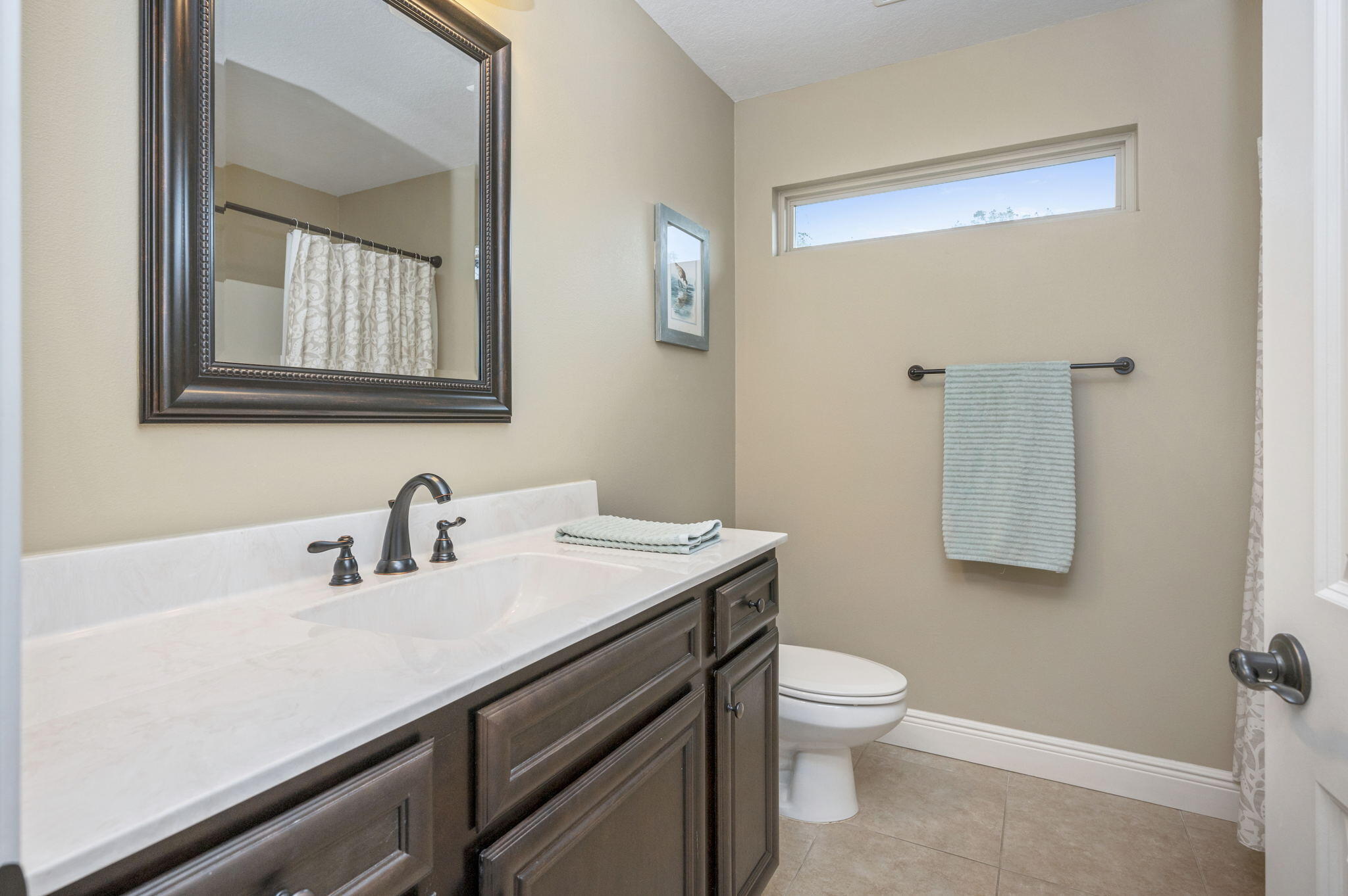 5811 Roberts Road Crestview, FL 32536 - Photo 29 of 35 a bathroom with a toilet a sink a mirror and a window