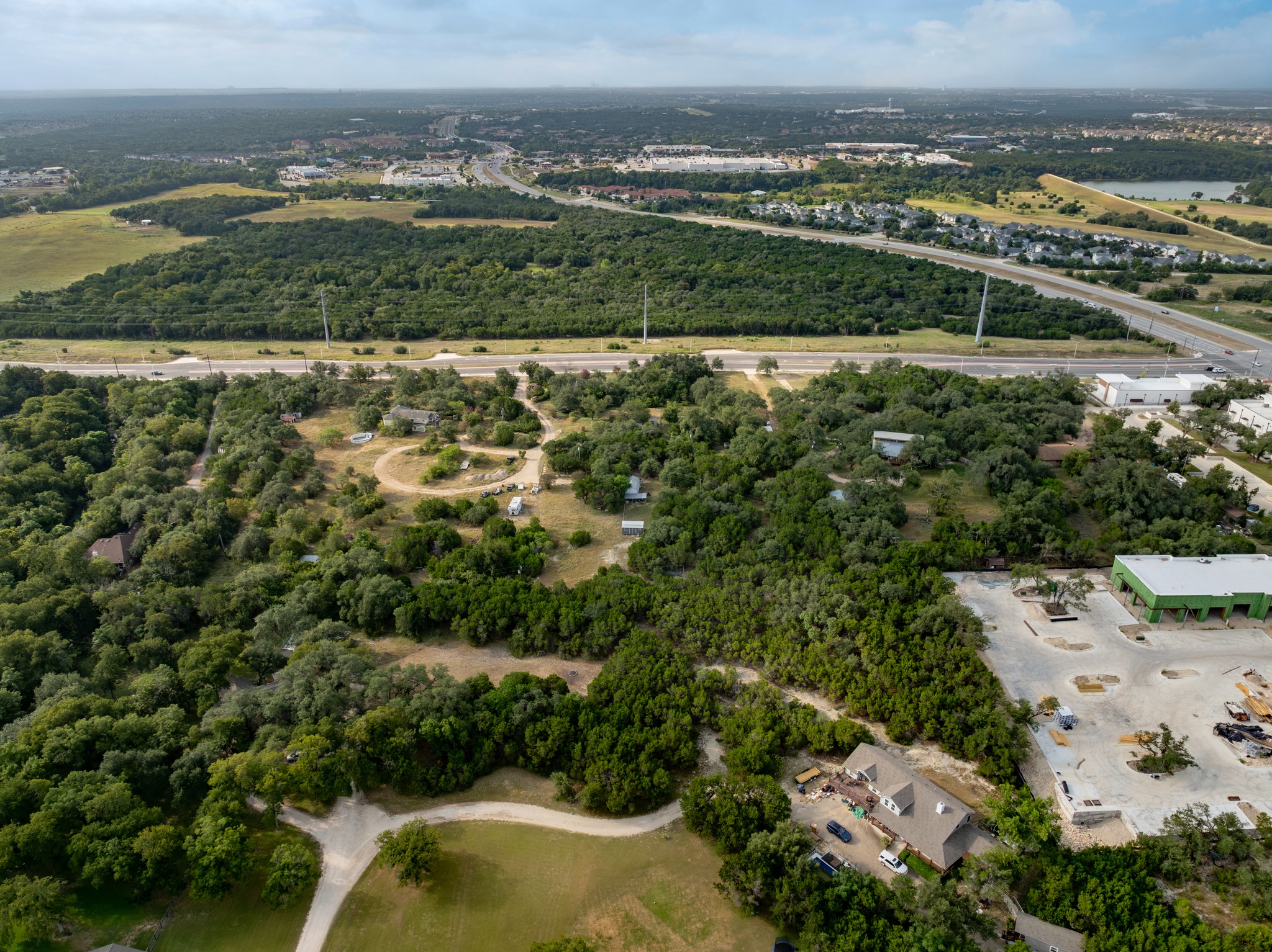 5021 Little Valley Road Leander, TX 78641 - Photo 27 of 32 High aerial context view of dense woodland, residential area, and nearby commercial development.
