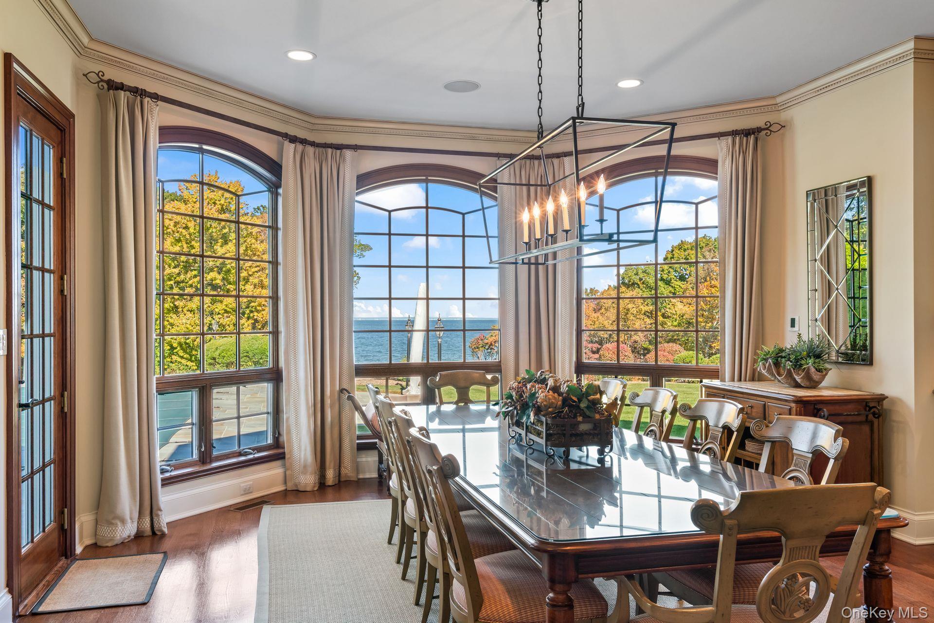 697 Short Beach Road Nissequogue, NY 11780 - Photo 19 of 46 a dining room with furniture a chandelier and wooden floor