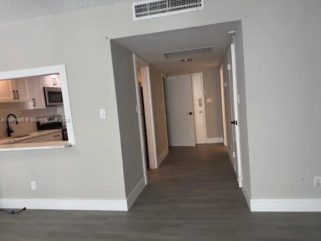 a view of a hallway with wooden floor