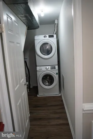 a utility room with wooden floor washer and dryer
