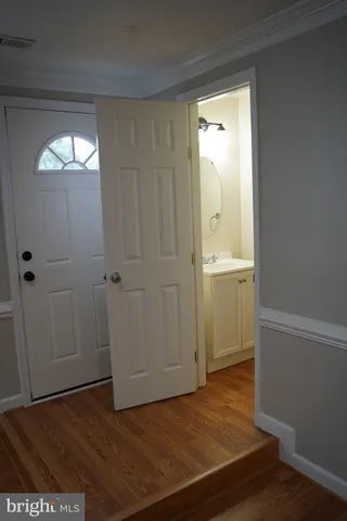 an empty room with wooden floor and mirror