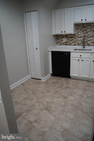 a view of kitchen with granite countertop cabinets