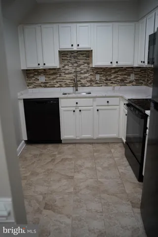 a kitchen with granite countertop a stove top oven sink and cabinets