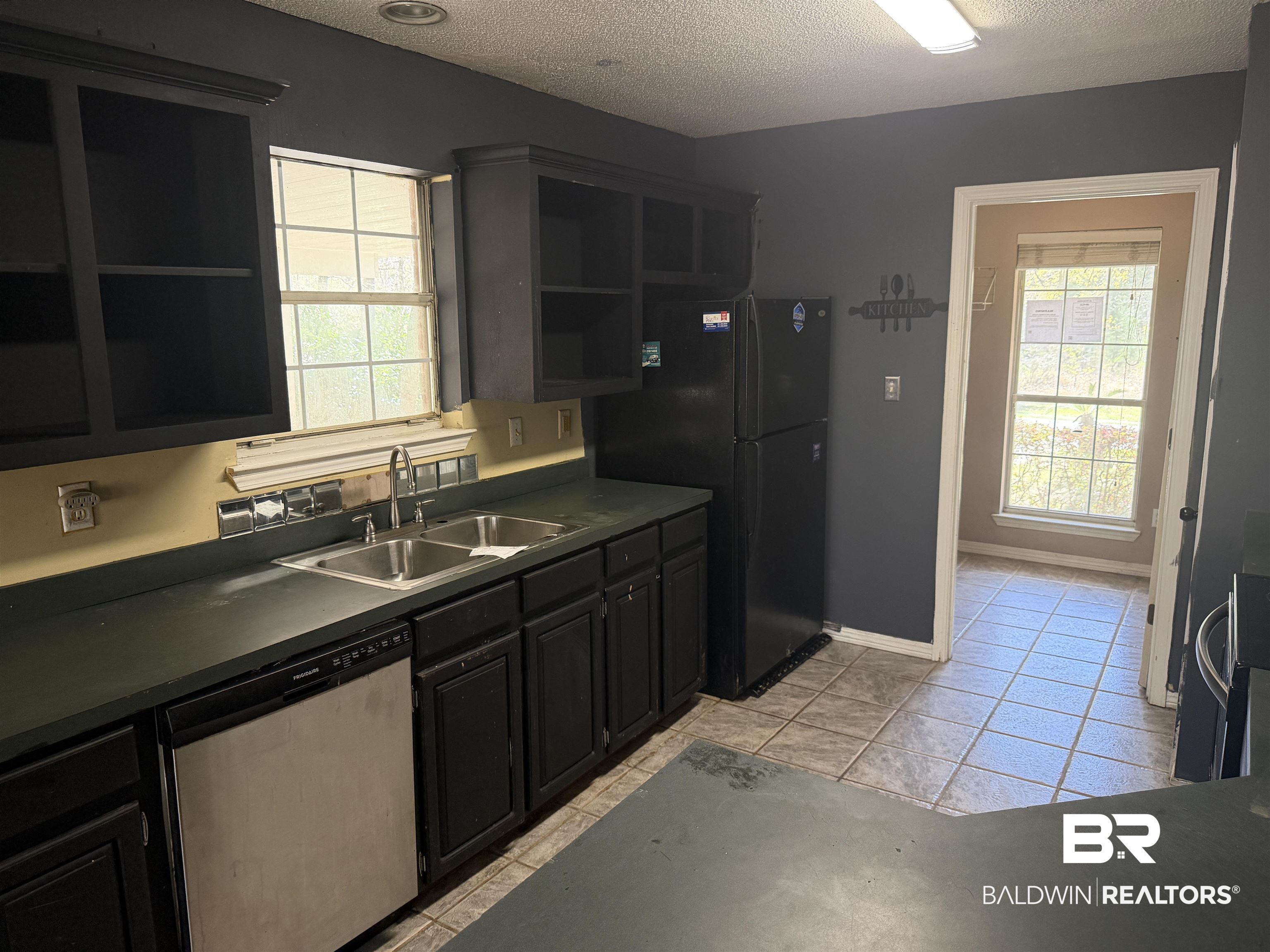 7067 Pinehill Road Daphne, AL 36526 - Photo 7 of 18 Kitchen with dark countertops, open shelves, dishwasher, dark cabinetry, and a textured ceiling