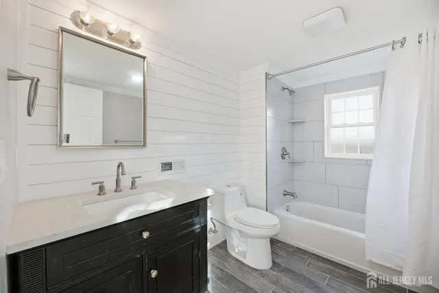 a kitchen with granite countertop a refrigerator a sink and white cabinets
