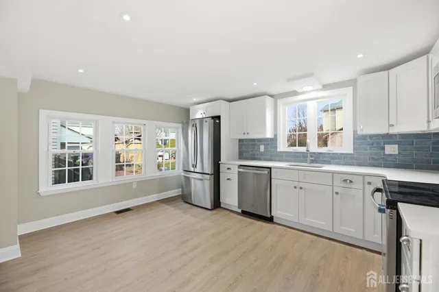a kitchen with a refrigerator sink and cabinets