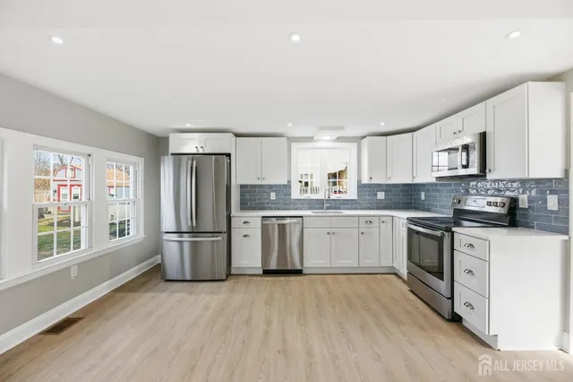 a kitchen with white cabinets stainless steel appliances and sink