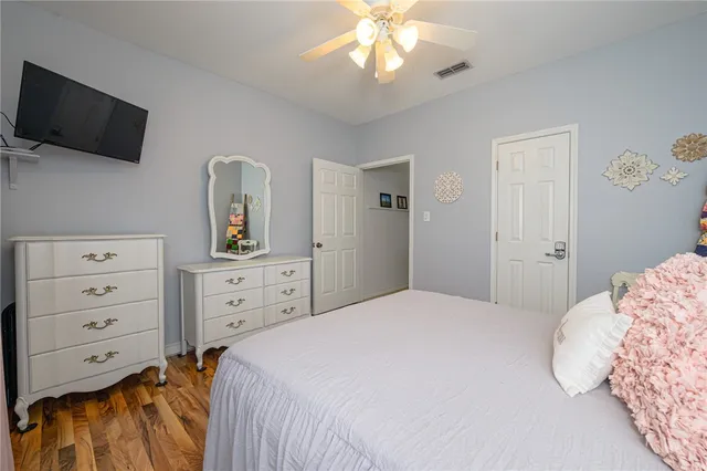 a bedroom with a large bed and a flat tv screen on dresser
