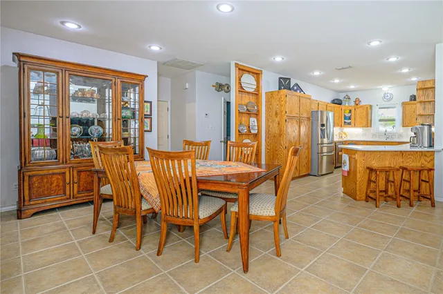 a dining area with stainless steel appliances a dining table and chairs
