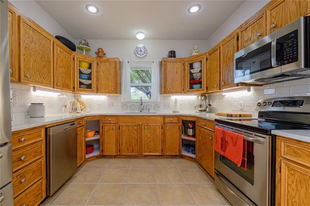 a kitchen with stainless steel appliances granite countertop wooden cabinets a sink and dishwasher