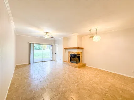 a view of empty room with fireplace and fan